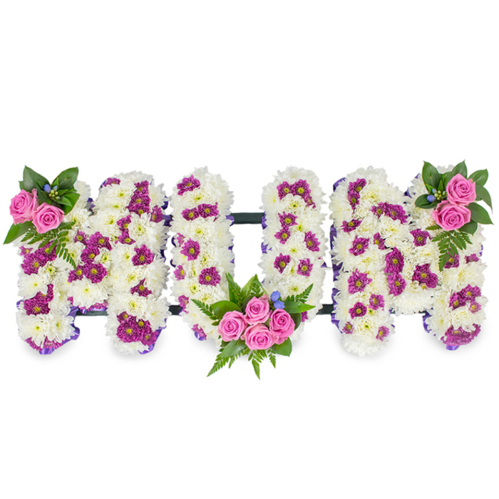 Presented against a clean white backdrop, this bespoke sympathy design spells MUM in three substantial, sculpted letters, each carefully constructed from a thick, velvety layer of immaculate white chrysanthemums. The white chrysanthemum base reads soft and enduring, a downy canvas punctuated by calibrated patches of deep purple and magenta spray chrysanthemums that add pattern, shadow and richness to each letter. Bright pink spray roses are arranged as three thoughtful bouquets: a small, elegant pair or trio at the top left of the first M, a more generous cluster cradled in the lower curve of the U surrounded by fern fronds and lush green leaves, and a mirrored rose-and-greenery grouping at the top right of the final M. Tiny blue accent flowers peek through the foliage, lending coolness and a hint of contrast to the otherwise warm palette.

A slim dark bar runs horizontally behind and between the letters, giving the whole tribute a composed silhouette and practical support; some versions are edged with a narrow purple ribbon to subtly emphasise the letter contours. Under subdued, natural light the chrysanthemums' texture becomes tactile in description - cloud-soft and densely layered - while the pink roses provide concentrated points of colour and a gentle fragrance. The design balances craftsmanship with emotional clarity: it comforts without ornament, speaks of memory and careful mourning, and feels handcrafted rather than mass-produced.

This arrangement is particularly suited to memorials or funeral services in and around Highgate - whether held near Waterlow Park, on Highgate West Hill, or within the quiet lanes of Highgate Village - and reflects the local florist's attention to detail, freshness and respectful delivery for bereavement occasions.