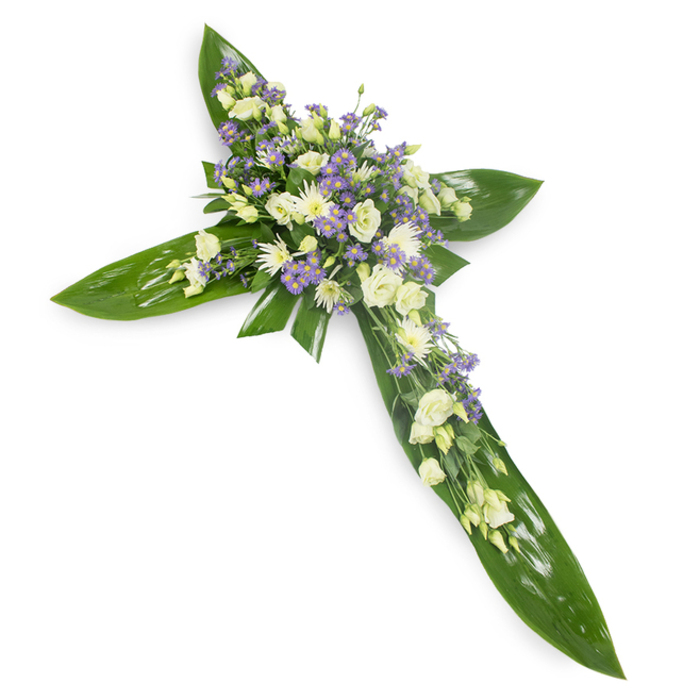 Viewed from a slightly raised angle on a pristine white surface, this floral cross is composed of a verdant scaffold of large, glossy tropical leaves whose smooth, veined faces catch a soft, even light. The leaves form the arms and center of the cross with a disciplined, artful geometry that feels both strong and protective. At the heart of the cross, and continuing modestly along each arm, sit abundant clusters of creamy ivory lisianthus, their layered, delicate petals unfurling with subdued elegance, paired with compact white chrysanthemums that introduce a crisp, luminous texture. Intermingled throughout are sprays of small lavender-hued flowers-likely limonium or petite asters-that provide a gentle cool contrast and visual depth, like distant violet notes in a quiet landscape. Slender, fine greens are threaded between the blossoms, enhancing the natural, garden-sourced aesthetic and softening the transition between bloom and leaf. The overall mood is one of serene reflection; the scent would be faintly herbaceous and floral rather than overpowering. This arrangement is particularly suited to faith-based memorials and peaceful funeral services in the Highgate area-places such as the cemetery chapel or local parish halls-where a restrained, respectful floral tribute is sought to convey sympathy, comfort, and hope.