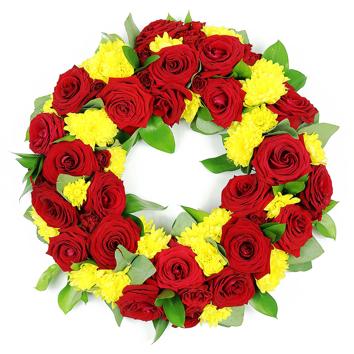 A richly detailed funeral wreath is displayed against a stark white background, its circular form filled edge to edge with crimson red roses and sunny yellow chrysanthemums, evoking both solemnity and a gentle celebration of life. The design would feel at home at a remembrance service in Highgate, with its mature trees and calm, historic surroundings. The main body of the wreath consists of dozens of fully open red roses whose velvety petals curl gracefully outward. The colouring within each bloom moves from deeper burgundy shadows at the centre to lighter crimson at the tips, lending the arrangement a sense of depth and quiet drama. Interspersed throughout are numerous clusters of small, button-like yellow chrysanthemums. Their fine, narrow petals create fluffy, rounded shapes that contrast beautifully with the smoother rose petals, adding a lively, sunlit quality that softens the overall mood. Between and around the flowers, an abundant mix of green foliage provides structure and balance. Some leaves are broad and glossy, reflecting the light in soft highlights, while others appear more slender and slightly muted, with a silvery-green tint typical of eucalyptus. This foliage ensures that the wreath feels full and natural, echoing the greenery found in places like Highgate Wood and the slopes around the cemetery. The arrangement forms a perfect, unbroken circle with an open centre, a traditional symbol of eternity, continuity, and unending love. Bright, even lighting accentuates each curve and texture, allowing the richness of the reds, the cheer of the yellows, and the calming greens to stand out distinctly. The result is a balanced and dignified floral tribute, suitable for funerals, memorial gatherings, or meaningful anniversaries of loss in the local community.