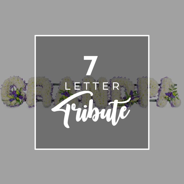 A poised and understated memorial composition is shown against a soft grey background, where a darker central square, edged in white, acts as a focal point. Inside this square, crisp white typography spells out 7 LETTER Tribute: the number 7 appears strong and prominent at the top, the word LETTER follows in a smaller, precise sans-serif font, and the word Tribute is written below in an elegant, sweeping script that softens the overall look. Behind this graphic, extending to the left and right yet partly hidden, is a seven-letter floral tribute forming the word GRANDMA. Each upright letter is carefully formed from a lush covering of small white chrysanthemums or comparable flowers, their rounded petals creating a soothing, plush texture. Along the contours of each letter, accents of rich purple blooms are carefully tucked in-perhaps lisianthus or compact roses-interwoven with fresh green foliage. These touches of purple and green enliven the white base without overpowering it, offering a balance between purity, dignity, and natural vitality. The lighting is even and gentle, allowing you to imagine the subtle shadows between petals and the slight sheen on each leaf. This arrangement feels like something commissioned from Flowers Highgate by a family seeking a refined, personal tribute for a funeral service, whether at a nearby church or at one of the crematoria reached easily from Highgate. The word GRANDMA, rendered entirely in flowers, becomes a quiet centrepiece of remembrance, capturing both the softness of affection and the formality of a final goodbye.