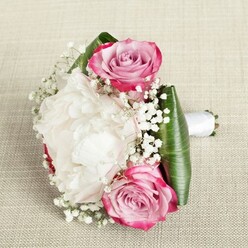 In this artful bouquet, Highgate's romantic spirit is caught in exquisite detail. Two prominent pink roses are the bouquet's focal points, their boldly coloured fuchsia outer petals blending beautifully into rosy blush and lavender at the tightly nested cores. The centrepiece-a stunning, cloud-like white peony-unfolds in layers of silky, ruffled petals, reminiscent of classic bridal luxury and the refined walks through Highgate Village. Airy tendrils of baby's breath drift throughout, filling spaces between the larger blooms with fine, white delicacy and a fairy-tale shimmer. A structural base of glossy, broad green leaves-likely ti or similar tropical foliage-encircles the blossoms, accentuating their vibrancy and providing a clean, tailored silhouette. All stems are elegantly gathered in a crisp white satin ribbon, its gentle sheen echoing the softness of the surrounding flowers. Set against a neutral, lightly woven background, the bouquet is illuminated by gentle, diffuse light, bringing out subtle details and natural colour transitions. Crafted with the keen eye and gentle touch of a Highgate florist, the arrangement is perfectly suited for weddings, anniversaries, or cherished moments-carrying with it the timeless elegance and celebration so familiar across the area's beautiful homes and old-world charm.