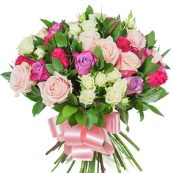 This dense, vibrant bouquet is pictured on a clean white backdrop so every petal and leaf is clearly visible - a carefully balanced hand-tied arrangement of mixed roses and lush greenery that reads both elegant and exuberant. Large classic roses in soft pastel pink and creamy white form the principal volume, their petals unfurling in broad, satiny spirals; interspersed among them are bright magenta-pink blooms that bring energy and a few lavender roses that introduce a calm, cool contrast. Small spray roses in creamy white with suggestions of pale yellow add delicate, clustered texture between the larger blooms, enhancing depth and visual rhythm. Dark green, glossy foliage - likely ruscus or salal - is woven throughout, its long, linear leaves offering crisp contrast and a verdant frame for the roses. The stems are gathered into a substantial hand-tied base and finished with a wide, pale pink satin ribbon tied into a generous bow whose lustre picks up the studio light, suggesting silk against skin. The composition suggests a soft, rosy scent and a tactile richness: petals that yield gently to the touch, leaves with a cool sheen, and the firm weight of bundled stems. Perfect for conveying affection or celebration, this bouquet evokes the charm of Highgate Village on a quiet morning and would be equally at home as a thoughtful surprise delivered to a home near Waterlow Park. Flowers Highgate's local experience shows in the neat gathering and considered colour play that make this arrangement feel personal and memorable.