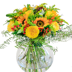This exuberant bouquet captures the spirited elegance of Highgate with bold sunflowers standing proudly at the heart of the arrangement, their golden faces and deep, warm centers turned outward as if chasing North London's gentle morning light. Framing them, plush yellow garden roses spiral open in creamy, enveloping layers, recalling the cultivated corners and soft meadows of Queen's Wood. Glossy red hypericum berries attach flecks of joyful contrast, much like glimpses of ruby treasures found along Highgate's leafy pathways. The bouquet's edge is softened by cascades of fine green ferns and plush filler, giving it a breezy, organic flow evocative of strolls through Highgate's many parks. Hidden among the brightness, eucalyptus leaves add subtle blue-green notes and a cool, refreshing aroma, conjuring memories of tranquil afternoons in Waterlow Park. Arranged in a crystal-clear glass vase, the bouquet's green stems appear vibrant and fresh, as if just gathered from an early morning garden. Meant to lift the mood and brighten celebrations for birthdays, reunions, or new beginnings in the Highgate area, this composition radiates warmth and joyful camaraderie, its artistry rooted in the expertise of local florists who know and love the community.