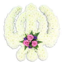 The image portrays a striking Sikh Khanda floral tribute, crafted with exceptional precision and displayed against a spotless white background that accentuates every curve and edge of the design. The main body of the Khanda is made entirely from tightly clustered white chrysanthemums, each flower head positioned closely to its neighbour so that the petals form a continuous, velvety texture. The central sword stands tall and straight, surrounded seamlessly by the circular chakkar, while the two kirpans fan outwards at the base, their shapes balanced and harmonious. The clean white flowers lend an air of purity and stillness, as if the arrangement has been prepared for a moment of quiet reflection in a Highgate chapel or a service near Highgate Cemetery. At the foot of the symbol, a small yet impactful accent bouquet introduces a gentle note of colour. Three pink roses sit proudly at the centre, their petals unfolding in tightly layered whorls, suggesting love, gratitude, and remembrance. Around them, deeper purple blooms provide contrast, their tones rich and solemn. Sprigs of green fern and foliage peek from behind, adding a natural, almost woodland softness reminiscent of the greenery around Hampstead Heath. The colours are modest yet meaningful, offering comfort without distracting from the white Khanda above. A subtle shadow beneath the tribute gives depth and makes the arrangement appear solid and present. This carefully constructed floral piece reflects both the reverence of Sikh religious symbolism and the compassionate craftsmanship of local Highgate florists, making it an especially fitting choice for funerals, memorial services, and moments when families wish to honour a cherished life with dignity and faith.