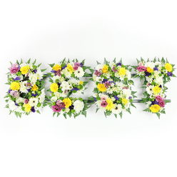 Presented on a clean white backdrop, four substantial floral letters spell BEST, each built from a lush, tightly packed assortment of fresh blooms and rich greenery. The primary palette is crisp white and cheerful yellow: large chrysanthemum-like white heads and sunlit yellow roses and gerbera daisies form the visual heartbeat of each letter. Interspersed among them are clusters of soft lavender and deep purple lisianthus or small chrysanthemums, adding a calm, reflective shadow to the composition, while bright fuchsia-pink spray roses or petite carnations provide lively punctuation. Smaller green-and-white filler flowers cushion the larger blooms and introduce delicate texture, making each letter appear like a cultivated meadow in miniature. Generous fronds of dark green fern frame the letters, softening their edges and lending a natural, leafy halo that contrasts with the bright petals. Through narrow crevices the dark-green or subtle metal framework that supports the structure is visible, particularly across the horizontal bar of the E and the top of the T, a reminder of the craftsmanship behind the display.

Shot straight on in even, bright light to capture true colour and petal detail, this tribute conveys both freshness and solemn beauty. As an experienced Highgate florist, Flowers Highgate composes pieces like this for memorial services, anniversaries, or celebrations of life - often requested by neighbours from the Highgate Village, near the Pond or the Cemetery - and can arrange delivery across Highgate and surrounding Crouch End and Muswell Hill. The effect is tender and respectful, meant to honour memory with clarity and grace.