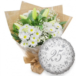 This photograph presents a thoughtfully crafted floral gift for a silver anniversary, the kind of arrangement often chosen by couples and families in Highgate to mark twenty-five years together. Dominating the left side of the image is a generous bouquet of fresh white flowers, hand-tied and slightly angled as if just set down on a table. White daisy-like chrysanthemums fill most of the space, each with a round, bright yellow centre that brings warmth and a subtle sense of nostalgia, like sunlight falling across the terraces near Highgate High Street. Among them, tall, slender lily buds stand gracefully, still closed with touches of pale green at their tips, promising elegant blooms in the days to come. Wisps of delicate white baby's breath thread through the bouquet, their tiny blossoms creating a soft, misty texture that balances the stronger shapes of the chrysanthemums and lilies. Dark green leaves gather around and beneath the white petals, adding depth, shadow, and a natural frame to the flowers. The bouquet is wrapped first in a layer of clear, slightly glossy cellophane, then enfolded in rustic brown kraft paper, carefully folded and gathered to create a gently structured silhouette. The stems are tied neatly at the base, making it ready to be carried through Highgate Village or delivered for an intimate anniversary dinner. To the lower right of the bouquet sits a round silver foil balloon, its metallic surface catching light in soft highlights and shadows. An intricate pattern of silver scrolls and floral motifs surrounds a central inscription of "25th" in flowing script, while faint repetitions of "Happy Anniversary" in the background complete the celebratory theme without overpowering the scene.