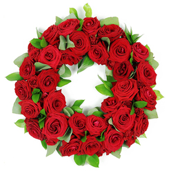 In my hands, this wreath of deep red roses feels ceremonial, every petal woven with care and reflection. The bloom range-from tightly closed buds to velvety, open blossoms-tells a story of vigilance and grace, while the surrounding greenery peeks through in silvery-green crescents, lending a breath of calm amid strong emotion. The roses, classic symbols of love and lasting devotion, create a mood of quiet reverence as their fragrance drifts like distant garden nights. Soft light washes the arrangement, highlighting the plush depth of each petal and imparting a warm, serene glow. This wreath is crafted as a sign of eternal connection, a comforting presence that says memories endure even as time moves on. In Highgate, such a piece is commonly chosen for memorials, funerals, and anniversaries, offered with discreet professional care by local florists. The circular form conveys continuity, while the dense packing invites the eye to linger, tracing the folds and shadows of crimson petals and the subtle sheen of green foliage. The greens-eucalyptus-like leaves and glossy ruscus-not only frame the roses but add texture you can almost feel as you run a hand along their surface. For nearby families, this wreath can be arranged with same-day delivery across Highgate, Muswell Hill, and the surrounding streets, a practical promise accompanying a profoundly emotional gesture.