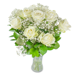 There is a calm, almost reverent quality to this arrangement: approximately twelve immaculate white roses, each with soft, creamy petals unfurling at their own pace so the bouquet reads as both perfectly composed and naturally alive. Interlaced between the roses are countless sprigs of baby's breath (Gypsophila), their tiny white blossoms forming a delicate mist that softens the stronger rose silhouettes and lends an airy halo to the composition. Beneath the blooms a variety of foliage-from deep, velvet-like emerald leaves to fresher, lime-green shoots-frames the flowers and provides a vivid counterpoint that accentuates the crispness of the whites. The entire grouping is cradled in a clear glass vase, the trimmed green stems visible through the water and adding an honest, botanical rhythm to the display. Against a clean, bright white background and gentle, diffuse lighting, textures are sharply defined: the satiny rose petals, the feather-light gypsophila, the glossy leaves. The fragrance is faint and fresh, a whisper of garden mornings rather than a strong perfume, which makes this bouquet suitable for intimate celebrations, weddings, or moments of remembrance. As a local florist in Highgate I would arrange these stems to suggest stillness and restraint, mindful of scale and balance so the bouquet reads beautifully from every angle. Flowers Highgate often prepares similar designs for deliveries around Highgate Village, Waterlow Park, and the surrounding streets when families request something quietly elegant for a special day or a thoughtful condolence.