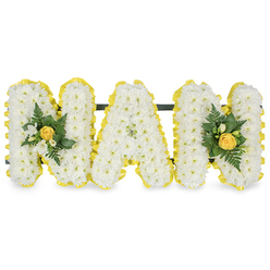 A tender, lyrical floral tribute conceived to honour a cherished grandmother, this arrangement spells the word MAM in three elegant capital letters and rests against a pure white backdrop. Each letter is composed of countless small white chrysanthemum sprays, packed so closely that the surface becomes a soft, almost cloud-like field of petals; the texture invites the viewer to imagine the subtle, familiar scent of chrysanthemum and the gentle crispness of each flower's edge. The perimeter of each letter is finished with a pleated, sunny yellow ribbon that folds and gleams like satin, crisply defining the form and adding a warm, uplifting frame. At either end, delicate accent clusters nestle against the first and last letters: a furled yellow rose sits at the heart of each cluster, surrounded by tiny white freesia or similar buds whose sweet, honeyed fragrance would lift a quiet room; lush dark green fern fronds and glossy leaves provide contrast and a feeling of fresh vitality. A narrow, discreet dark green support bar behind the upper sections connects the three letters for secure display, suitable for placement at a chapel or graveside. This piece, prepared with the sensitivity of an experienced local florist, reads as both dignified and intimate - a visual poem of memory and warmth. Flowers Highgate often prepares tributes like this for families gathering near Highgate Cemetery, Hampstead Heath, or the shops along Highgate Village, offering a comforting, personalised emblem of love and remembrance.
