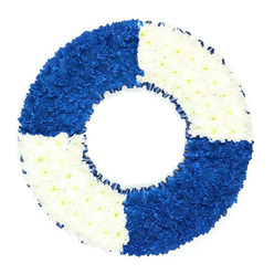 A carefully crafted circular floral wreath, styled to resemble a traditional maritime lifebuoy, is shown against a clean studio-white background, ensuring every shade and texture stands out clearly. The piece forms a perfect ring with a neatly defined central opening, the floral surface so densely arranged that the underlying base is entirely obscured. Hundreds of small, tightly clustered blooms-most likely chrysanthemums or similar button flowers-build up a padded, velvety texture, inviting the eye to wander over each gentle curve. The wreath is divided into four sharply defined segments that alternate between royal blue and pure white, mirroring the pattern of a classic life ring. The royal blue quadrants at the top left and bottom right carry a rich, almost regal depth, reminiscent of deep water or a navy ensign, while the white quadrants at the top right and bottom left feel airy and luminous, infusing the piece with a calm, contemplative light. A slender dark blue ribbon is tucked along the inner circle, softly ruffled, adding a discreet decorative border that reinforces the nautical idea without overpowering the flowers. There is a sense of strength and tenderness combined-the bold graphic contrast of the colours set against the softness of the petals. In Highgate, where hillside views and quiet streets invite reflection, this lifebuoy wreath would be a thoughtful choice for a funeral or memorial service, especially for someone linked to seafaring, rescue work, or simply known for guiding others through difficult times. It would sit beautifully at a crematorium chapel, church, or graveside, speaking gently of safe harbour, loyalty, and a life spent watching over others.