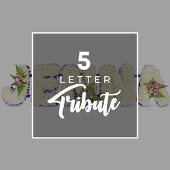 This image shows a beautifully composed five-letter floral tribute, photographed on a muted light grey background that allows every flower and ribbon detail to stand out. The letters are arranged in a straight horizontal line and are generously filled with fresh white chrysanthemums, the tightly packed blossoms forming a soft, cushion-like surface that feels welcoming and pure. Around the outline of each letter runs a neatly folded band of deep purple satin ribbon, its rich, jewel-like tone and gentle shine giving the design clarity and a graceful, ceremonial feel, as if it might be placed in a chapel or funeral home close to Highgate Village. Scattered thoughtfully across the tribute are petite clusters of accent flowers, featuring pale pink and lilac spray roses paired with light, airy fern fronds and sprigs of green foliage. These delicate touches bring in subtle colour and movement, reminiscent of the soft pastel shades you see in nearby Waterlow Park or on the flowered balconies along Highgate Hill. A square overlay, slightly darker than the background and framed with a fine white line, sits centrally on top of the arrangement, carrying the words "5 LETTER" in clean white capital letters above the word "Tribute" in a more flowing, script-style font. This overlay gently obscures parts of the letters, which appear to form "J", then "O", "H", "N" and an "A", illustrating how a loved one's name or a meaningful five-letter word can be spelled out for a funeral or memorial service. The entire scene conveys quiet respect, personalised care, and the kind of thoughtful, custom floral design that a local Highgate florist might create to help a family express their farewell in flowers.