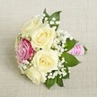Lovingly crafted by Flowers Highgate, this bouquet marries classic English romance with a contemporary twist. A handful of creamy roses, their petals unfurling softly, are nestled alongside a radiant magenta-pink rose, creating a sumptuous contrast that echoes the breathtaking sunsets over Hampstead Heath. Wisps of delicate white baby's breath cascade through the blooms, lending an air of lightness and purity, while deep green leaves peek from beneath, framing the composition and evoking the serenity of Highgate's lush neighbourhood parks. The bouquet's stems are wrapped in a striking pink satin ribbon and adorned with a winding line of petite white pearls, the shimmer catching the light and inviting admiring glances-just the touch for a refined wedding, bridesmaid's gift, or significant celebration in Highgate. Laid against a neutral linen surface, the arrangement glows with warmth, capturing both timeless beauty and the charm of locally inspired artistry for special occasions in this historic North London enclave.