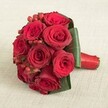 With a nod to the timeless beauty found across Highgate, this bouquet features ten spectacular deep red roses, each bloom perfectly open with silky, velvety petals that glow in daylight. Vibrant red hypericum berries are tucked thoughtfully among the roses, introducing glimmers of cheerful color and captivating texture. The bouquet's base is meticulously framed with broad, emerald green leaves, their elegant curvature highlighting both the shape and vibrancy of the arrangement. A smooth red satin ribbon binds the stems, creating a handle that feels as refined as the bouquet itself-reminiscent of those cradled by brides in Highgate's graceful lanes. The bouquet rests upon a neutral linen background, softly lit so each nuance stands out: the lush folds of the roses, the reflective gleam of berries, the neat wrap of the satin ribbon. This classic arrangement suits weddings near Pond Square or memorable anniversaries in Highgate's historic homes, beautifully conveying themes of love, commitment, and handcrafted excellence. The composition is a tribute to both nature's splendor and the thoughtful artistry of Highgate's local florists, available for heartfelt delivery throughout the area.
