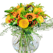 Evoking a walk along Highgate's leafy lanes on a radiant summer day, this vibrant bouquet of sunflowers and yellow roses announces itself with unbridled warmth. The sunflowers, with their broad golden petals and anchoring brown centers, seem to radiate joy from the center of the round glass vase, while butter-yellow garden roses nestle around them, each petal opening with classic English charm. Glossy hypericum berries, glowing in deep crimson, dot the display and add a playful counterpoint to the softer yellows. Wisps of airy, emerald fern fronds, light golden solidago, and soft eucalyptus sprigs add both volume and gentle movement, creating a sensation of breeze and freshness that mirrors Hampstead Heath's open expanses. The clean lines of the transparent vase reveal an artful tangle of stems, while water glistens beneath-a detail that speaks to the bouquet's tranquil, revitalizing presence. Whether intended for a birthday near Pond Square or to brighten a living room in Dartmouth Park, this joyful arrangement captures the essence of Highgate's relaxed elegance and friendly hospitality.
