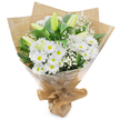 A carefully hand-gathered bouquet of pristine white blooms sits upright against a clean white background, the composition breathing quiet elegance. At the heart of the arrangement a generous cluster of daisy-like white chrysanthemums forms a soft, textured dome; each bloom radiates dozens of narrow petals from a pale, sunny yellow eye, catching light like small porcelain suns. Taller, elongated lily buds-pale green leaning to soft yellow with faint longitudinal striping-rise above and between the chrysanthemums, their closed forms promising a second act of fragrance and blossom. Fine, cloud-like sprays of baby's breath (Gypsophila) are woven throughout, lending an ethereal, lacey veil that softens edges and creates gentle pockets of air around the larger flowers. Deep, glossy green foliage frames the bouquet, the leaves' rich tones setting off the crisp whites and adding depth to the silhouette.
The bouquet is wrapped with a two-layer finish that balances rustic charm and practical protection: an inner sheet of crinkled brown kraft paper adds an earthy, tactile base while an outer clear cellophane sheath catches highlights and keeps stems sheltered. The wrapping is gathered and tied at the base to form a neat, portable stand so the stems sit upright for presentation or carriage. In soft morning light-the kind you might find wandering past Highgate Village or pausing by the pond-the arrangement seems to radiate calm and thoughtful care.
Texturally and aromatically restrained, the bouquet suggests purity, solace, and gentle celebration. It's the sort of hand-tied posy appropriate for a birthday in a Hampstead flat, a quiet condolence left near Highgate Wood, or a simple 'get well soon' carried along Archway Road. The composition reads as timeless and compassionate, a floral note that speaks when words feel small.