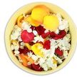 The photograph shows a gently rounded bowl of soft primrose-yellow ceramic viewed from above, brimming with fresh petals arranged as a subtle yet meaningful funeral tribute. Inside, the petals sit in a loose but generous mound, completely covering the bowl's interior. Most are rose petals, broad and velvety, layered in shades of deep crimson red, radiant golden yellow, and mellow peach or apricot, their edges slightly curled as though recently plucked. Woven between them are myriad tiny white petals resembling hydrangea florets, each with a faintly ruffled, papery edge that contrasts with the smoothness of the roses. The interplay of the strong colours with the pure white accents creates a balanced, harmonious palette that feels both dignified and comforting. Soft, even light from above reveals subtle shadows nestled in the folds of the petals, lending depth without disturbing the arrangement's calm mood. This kind of petal-filled bowl is the sort of piece one might place at a remembrance gathering in Highgate, perhaps on a side table in a home overlooking the slopes towards Hampstead Heath, or by the entrance of a chapel where mourners pause to reflect. The petals could be used in a scattering ritual, each colour echoing different memories and emotions-love, joy, gratitude, and quiet peace. Though small in scale, the image communicates a powerful sense of tenderness and respect, offering a gentle, tactile focus for those seeking comfort during a time of loss.