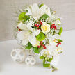 On a clean, white tabletop, a sophisticated white and green arrangement is displayed in front of a warm beige backdrop, evoking the calm of a Highgate sitting room filled with natural light. The bouquet is full and carefully shaped, with bold white Oriental lilies taking center stage, their wide petals unfurled to reveal delicate speckling and pronounced stamens that lend subtle drama. Close by, a beautifully formed yellow rose nestles among the lilies, its buttery petals tightly curled in an elegant spiral that glows against the cooler whites. Whisper-light sprigs of baby's breath are threaded throughout, introducing a cloud-like softness that blurs the boundaries between the flowers. Vivid green dianthus, shaped like neat, mossy spheres, add structure and a modern twist, reminiscent of sculpted topiary in nearby gardens. Airy, light green foliage fans out from the heart of the arrangement, giving it both depth and a natural, garden-inspired energy, as if it could have been gathered from a refined Highgate terrace. Bright red hypericum berries are scattered deliberately through the design, their glossy surfaces catching the light and adding a touch of festive cheer. Along the right-hand side, a cascade of white Phalaenopsis orchids tumbles gracefully downward, each bloom with silk-like petals and a hint of yellow at its center. Slender buds and spiky green details accompany the orchids, contributing to the bouquet's sense of movement and life. The entire composition sits in a low white woven basket, with two matching wicker spheres placed to the left on the table, echoing the basket's texture and creating visual balance. Illuminated evenly, every petal, leaf, and berry is clearly defined, forming a centerpiece that would look perfectly at home at a Highgate wedding reception or celebratory dinner.