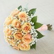 Glowing with delicate romance, this hand-tied bouquet is the epitome of grace-perfect for life's most treasured occasions in Highgate. Close-knit peach and apricot roses, their petals opening in flawless symmetry, form the heart of the design, each one a symbol of hope and loving anticipation that might evoke memories of moments shared on Hampstead Lane. Subtle, lace-like filaments of gypsophila trace between the roses, wrapping them in a soft, cloudlike embrace, while sleek, rich green leaves provide grounding and vivid contrast. The stems are elegantly bound with a peach satin ribbon adorned by a sprinkle of dainty white pearls, lending a classic, tactile finish ready for a bride's hand or as an anniversary tribute. Lit naturally, the bouquet's colours and textures resonate with joy, quiet confidence, and new beginnings. The scent, sweet yet airy, fills the senses like a fresh breeze over Waterlow Park. This bouquet, crafted by Flowers Highgate, stands as a timeless emblem of heartfelt celebrations, echoing the community's warmth and refined taste.