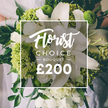 A luxurious Florist Choice bouquet unfolds with serene, pristine elegance, its heart lit by large white lilies whose petals unfurl in soft, cathedral-like arches. They are surrounded by smaller, multi-petaled white blooms-suggestions of ranunculus or roses-whose quiet layers add volume and a touch of vintage romance. Interspersed throughout are lime-green clusters whose texture and brightness read as a contemporary accent, reminiscent of Green Trick dianthus or compact green hydrangea heads, giving the arrangement a bold, modern spark against the purity of white. Rich, dark green foliage-eucalyptus and ruscus-weaves through the stems, lending depth, movement, and a lush base to the bouquet. The overall composition feels like a refined fusion of classic floral elements and contemporary design, crafted with the practiced eye of a Highgate florist. The bouquet appears to be held by someone in a pale wedding gown, the upper background softly blurred to emphasize the blossoms while hinting at a grand occasion along the Highgate lanes. Centered over the bouquet, a clean white rectangular frame bears the text: Florist Choice at the top in an elegant script, followed by BOUQUET in a bold uppercase sans serif, and a prominent ?200 at the bottom. This image, from Flowers Highgate, signals a premium gift suitable for weddings, anniversaries, or celebratory milestones. It conveys freshness, artistry, and reliable delivery, with availability across Highgate Village, Waterlow Park, and adjacent districts, including same-day options where offered. The frame and typography combine to showcase a ready-to-order luxury that captures the spirit of Highgate's refined, village-flavoured ambience.