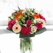 This bouquet is a burst of happiness preserved in time, inviting you to share in the effervescent spirit of Highgate. Lively orange gerberas radiate sunshine and joy, harmonising with the blushing pink of roses and the sumptuous, velvety tone of magenta carnations, much like the colours scattered across Waterlow Park in bloom. Creamy ivory roses and soft peach gerberas lend an air of gentle sophistication, tenderly balancing the vibrant palette. Crisp, glossy greens provide the bouquet's backbone, their richness reminiscent of strolls beneath the tall trees of Highgate Wood. Bathed in bright, almost magical daylight, every petal and shade dances-the essence of a celebration, milestone, or any cheerful moment in need of an expert touch. Lovingly crafted by a Highgate florist, this bouquet promises to uplift spaces and spirits throughout the neighbourhood, echoing the welcoming beauty of the local community.