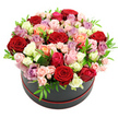 A modern black round hat box holds an overflowing crown of roses, captured against a stark white background that accentuates the bouquet's colour and form. The roses are massed so tightly that they create a smooth, domed canopy above the box, the blooms just spilling over the rim to suggest abundance and generosity. Throughout the arrangement, tones of deep scarlet red, powdery blush pink, bold fuchsia, creamy ivory, pure white, warm peach, coral, and gentle lavender and mauve merge into a rich, painterly palette. Some roses are fully open, showing off sumptuous, layered petals that curl softly at the edges, while others appear as smaller spray roses, with compact heads and buds that bring finer texture and a sense of unfolding life. Crisp, bright green leaves weave discreetly among the petals, their fresh colour lifting the composition and keeping it lively and garden-like rather than overly formal. The hat box beneath is a smooth, matte black cylinder, finished at the bottom with a neat red trim or ribbon that echoes the passion of the red roses and gives the design a polished, gift-ready feel. It is easy to imagine this arrangement being prepared at Flowers Highgate and then carried along the tree-lined streets to a home near Highgate Wood or a rooftop flat with views over the city. Though the photograph cannot capture fragrance, the roses appear freshly cut, cool to the touch and lightly scented, embodying the artistry of a skilled florist crafting a piece that speaks of romance, celebration, and heartfelt appreciation in equal measure.