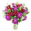 A lush, rounded bouquet of deep crimson roses and vivid magenta-purple carnations sits in a clear glass vase, pictured against a clean white backdrop. The roses range from tight, velvet-lined buds to gently unfurling blooms whose spiraled centers reveal layered, sumptuous petals; their colour reads as a saturated, romantic crimson that anchors the composition. Interwoven among them are abundant, ruffled carnations in a near-fuchsia purple, each frilly bloom offering a feathery, tactile contrast to the roses' smooth velour. Bright, glossy greens-likely ruscus and similar foliage-form a generous, verdant cradle, while scattered sprigs of silvery eucalyptus lift the arrangement with pale-green highlights and a whisper of modern freshness. The stems are visible through the simple glass vessel, giving the design an honest, freshly-cut look and a sense of cool, botanical weight.
Under soft, even light the textures become evident: the plush velvet of rose petals, the layered crisps of carnation frills, and the sleek sheen of leaves. There is a faint, comforting suggestion of scent-a warm, classic rose perfume softened by the clean, citrusy note of eucalyptus-so the bouquet feels both intimate and uplifting. This arrangement reads as celebratory and deeply affectionate, suited to anniversaries, a heartfelt congratulations, or a romantic surprise. As a local touch, imagine it placed on a mantel in a Highgate Village café or delivered for a table at a friends' lunch near Waterlow Park-its colours would stand out beautifully against the neighbourhood's sandstone and greenery. A careful floralist's hand is evident in the balanced density and natural movement, making this an elegant, expressive gift for someone special in Highgate and the surrounding north London streets.