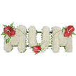 A dignified, three-dimensional floral tribute spelling MOM in bold capital letters, presented against a pristine white backdrop. Each letter is entirely covered with tightly clustered, small white spray chrysanthemums; their cushiony heads form a soft, cloud-like surface that both soothes the eye and suggests quiet peace. The chrysanthemums' delicate scent is faintly powdery, the texture plush under soft daylight, and a subtle dark green backing peeks around the edges to hold the freestanding shapes with neat structure. To punctuate the serenity, three glossy red blooms - likely anthuriums with their smooth, heart-shaped spathes and pale yellow-white spadices - are placed as focal accents: one on the upper left corner of the first M, one nestled low in the O, and a final mirror image atop the right corner of the last M. Each red anthurium carries a waxy sheen and is cushioned by sprays of deep green foliage - feathery ferns, broader laurel-like leaves and thin arching blades that lead the eye across the letters. Slender green stems curve gently between the red blooms, visually uniting the composition and suggesting a subtle, living ribbon. The overall mood is one of calm remembrance: a classic funeral or memorial piece conveying love, respect and lasting memory for a mother. Imagined in a quiet Highgate chapel or beside a grave in the shade of Highgate Cemetery, the arrangement reads as both personal and dignified, offering comfort through simplicity and considered floral craftsmanship.