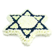 A striking Star of David floral arrangement fills the frame, its six-pointed shape composed with exacting precision from dense clusters of chrysanthemums and similar small blossoms. The outer silhouette of the star is illuminated by a wide border of crisp white flowers, their layered petals overlapping to create a soft, padded effect that conveys comfort and serenity. This sense of light continues into the centre, where a white hexagon and six small white triangles form a luminous core, like a calm focal point for reflection and prayer. Surrounding and intersecting these white sections, the two triangles that define the traditional Magen David are built from deep navy blue flowers, massed tightly to produce strong, uninterrupted geometric lines. The bold blue against the white strongly recalls the colours of the Israeli flag, emphasising the tribute's Jewish religious and cultural resonance. The arrangement is photographed on a plain white backdrop with balanced, even lighting, so no external elements compete with the symbolism of the star. There is no greenery, ribbon, or text-only the interplay of blue and white, carefully arranged by skilled hands. It looks like the kind of piece that might be carried into a chapel in Highgate, placed at the front during a Jewish funeral, or set beside a headstone in the quieter corners of Highgate Cemetery, where ivy-draped gravestones and tall trees create a contemplative atmosphere. The tribute feels both formal and tender, expressing love, continuity of faith, and communal support for the family, much as local florists in Highgate quietly support their neighbours in moments of loss and remembrance.